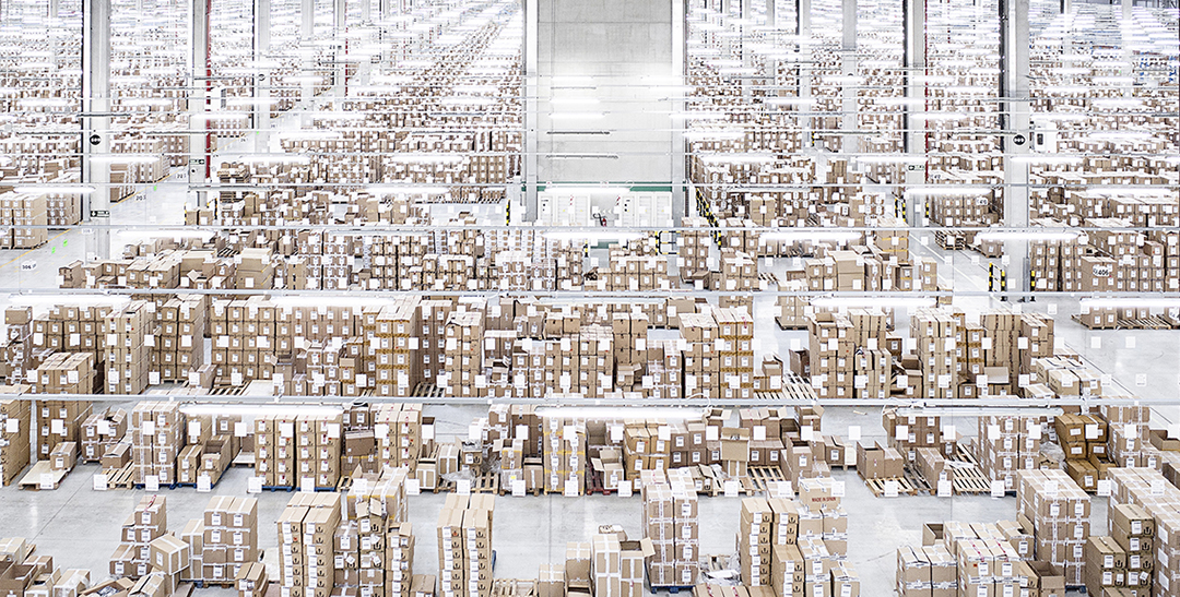 Almacén logístico masivo con miles de cajas apiladas hasta el fondo