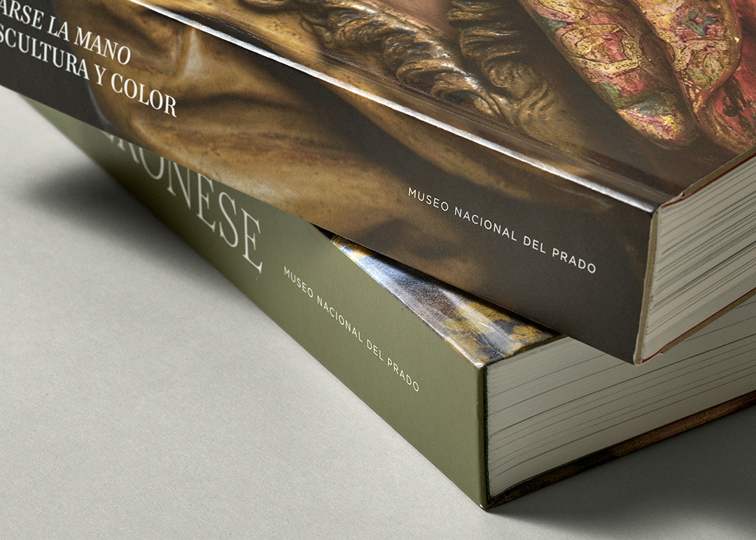 Detalle de dos catálogos editados por el Museo Nacional del Prado, apilados uno sobre otro, mostrando los lomos con títulos en tipografía blanca sobre fondos marrón y verde oliva. Los catálogos son 