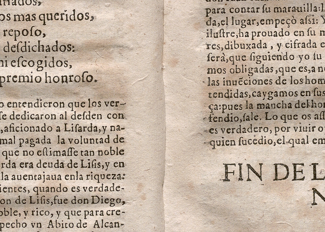 Libro antiguo abierto mostrando doble página impresa con texto en español y signos de envejecimiento.